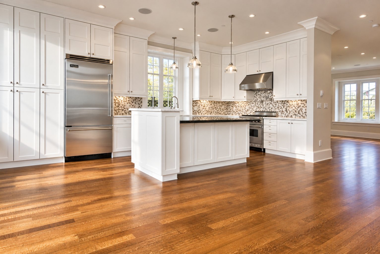 All-white kitchen with island, stainless Viking fridge and mosaic tile backsplash